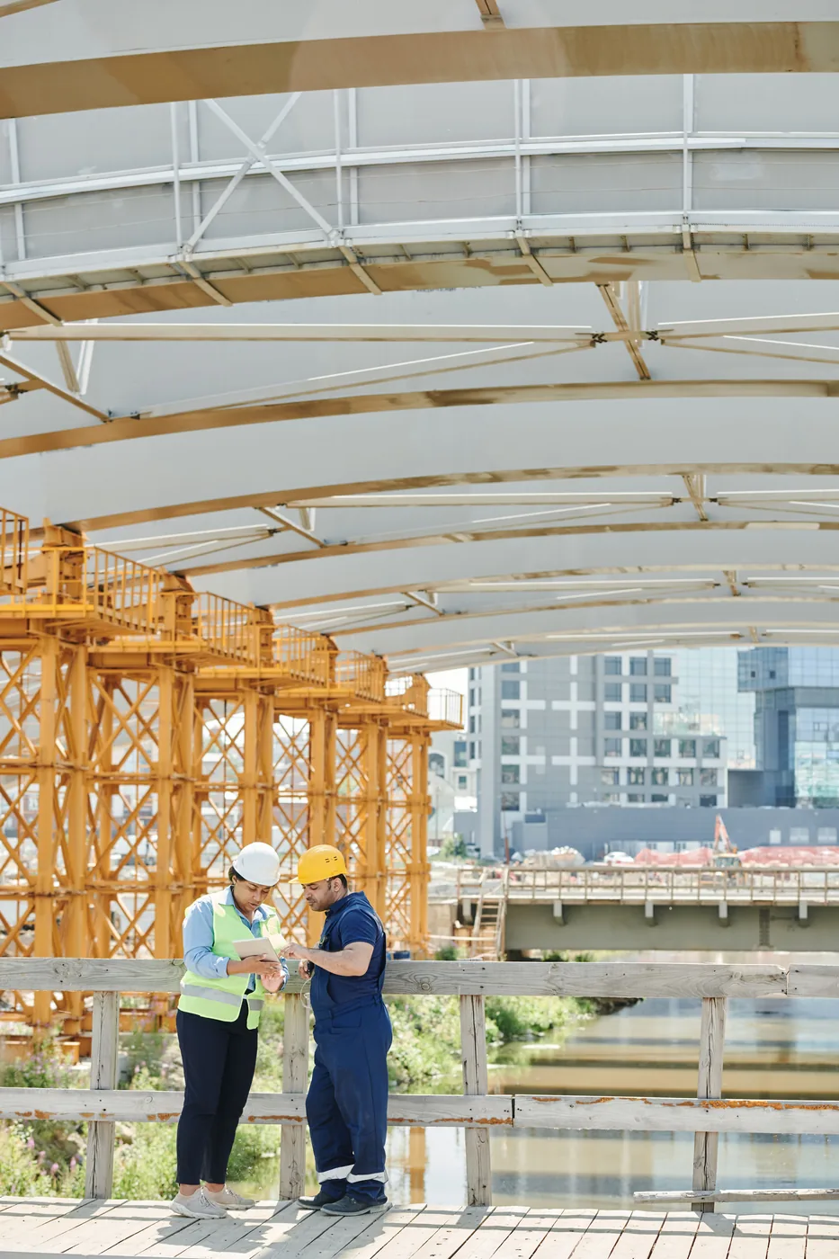 Construction site manager and contractor reviewing project plans on a tablet at a jobsite