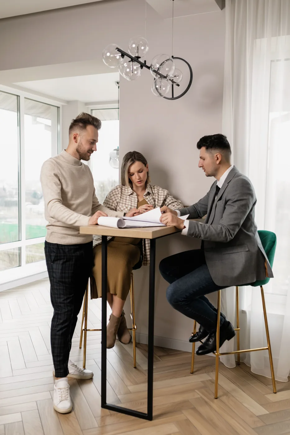 Real estate agent reviewing contract paperwork with clients at a table